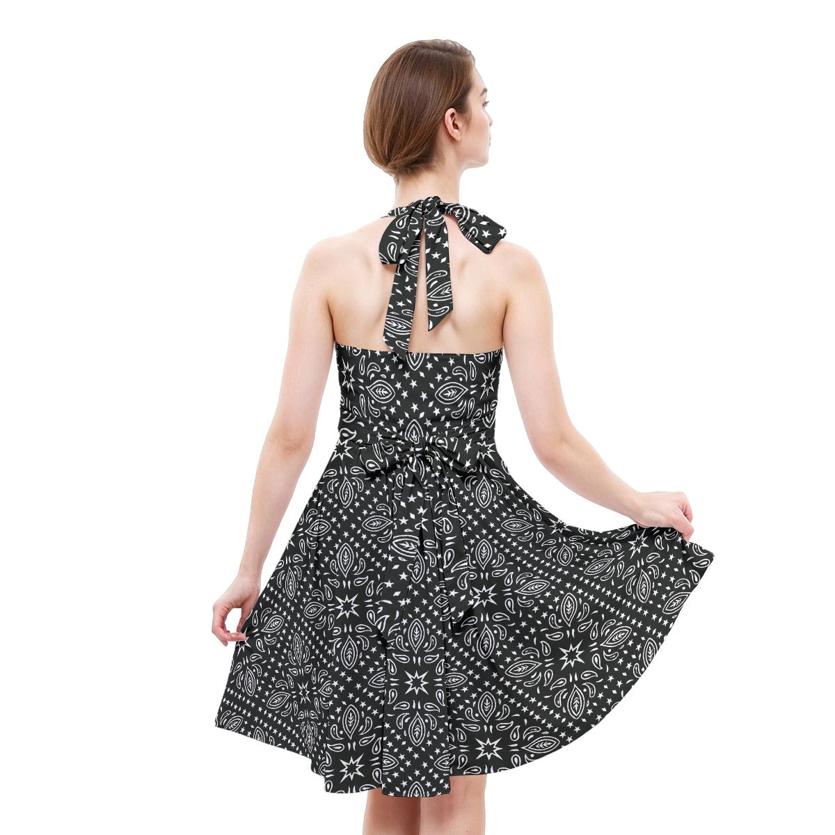 Woman wearing a black and white patterned dress with a scarf on a white background