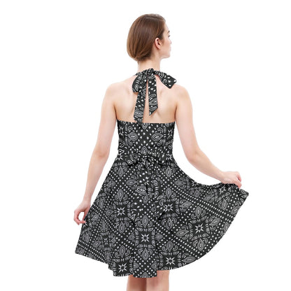 Woman wearing a black and white patterned dress with a scarf on a white background