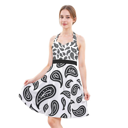 Woman wearing a white dress with black paisley pattern on a white background
