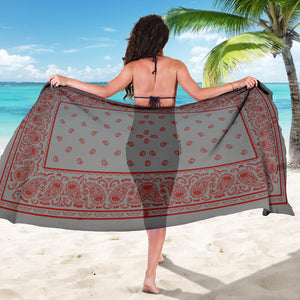 woman holding gray with red sarong